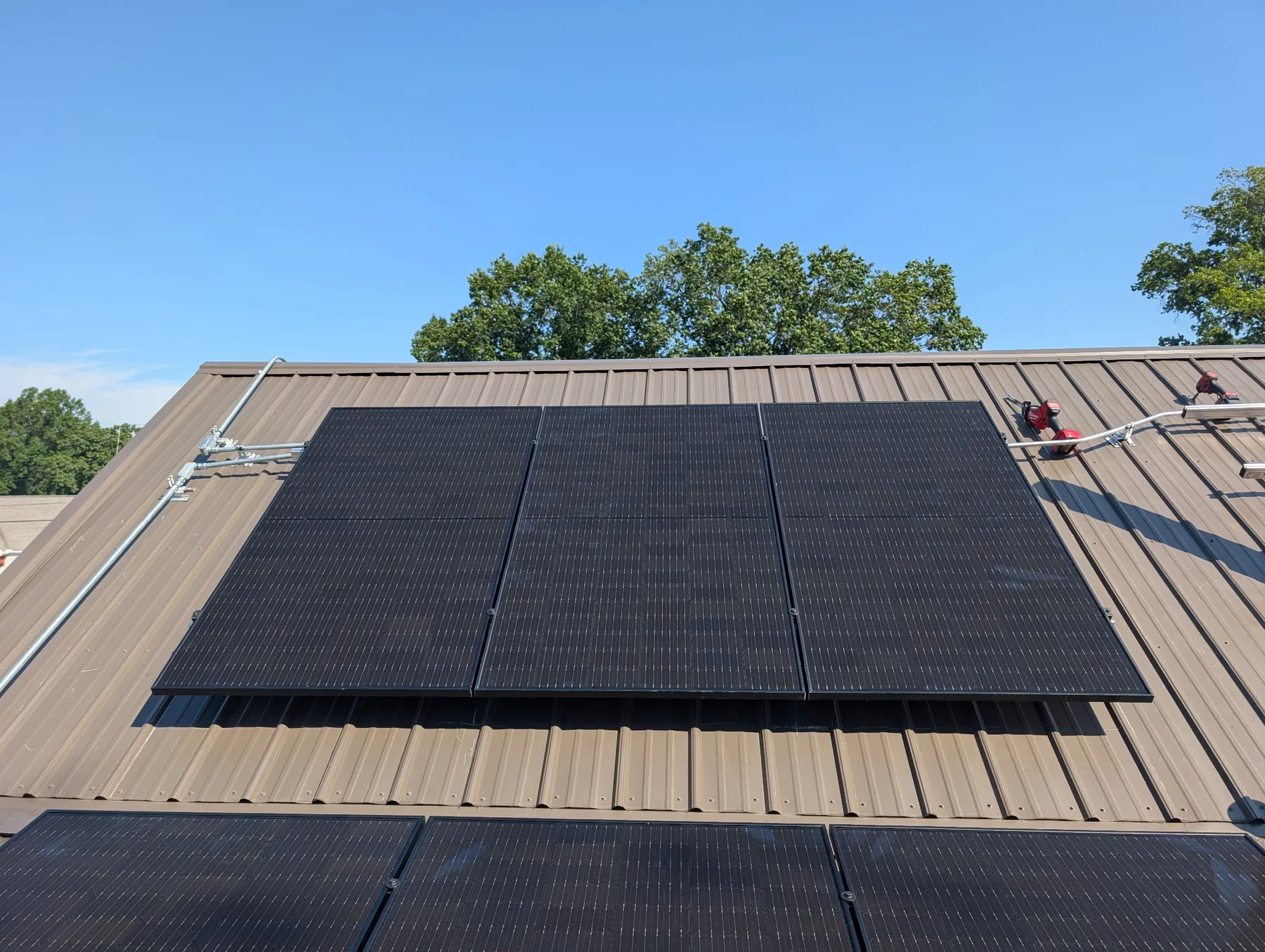 Solar panel array installed on a brown standing-seam metal roof